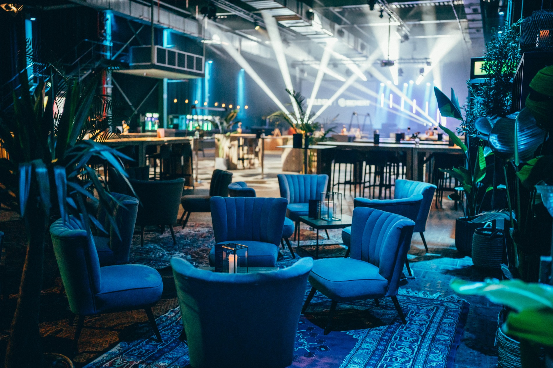 Großveranstaltung in einer Halle: Lounge-Möbel, Bar und Lichtshow am Abend