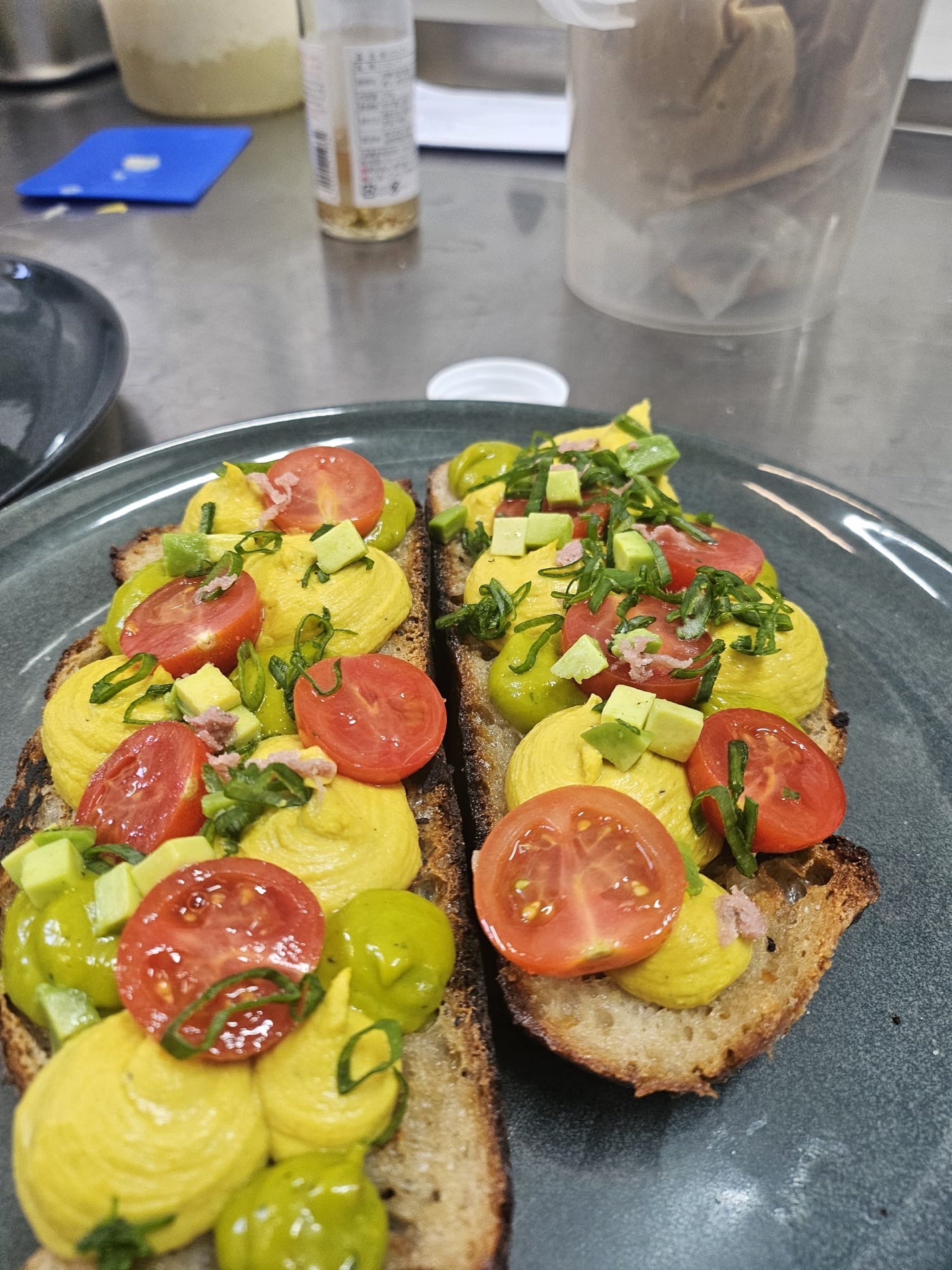 Belegtes Sauerteig-Toast mit Avocado und Tomaten fürs Büro-Lunch