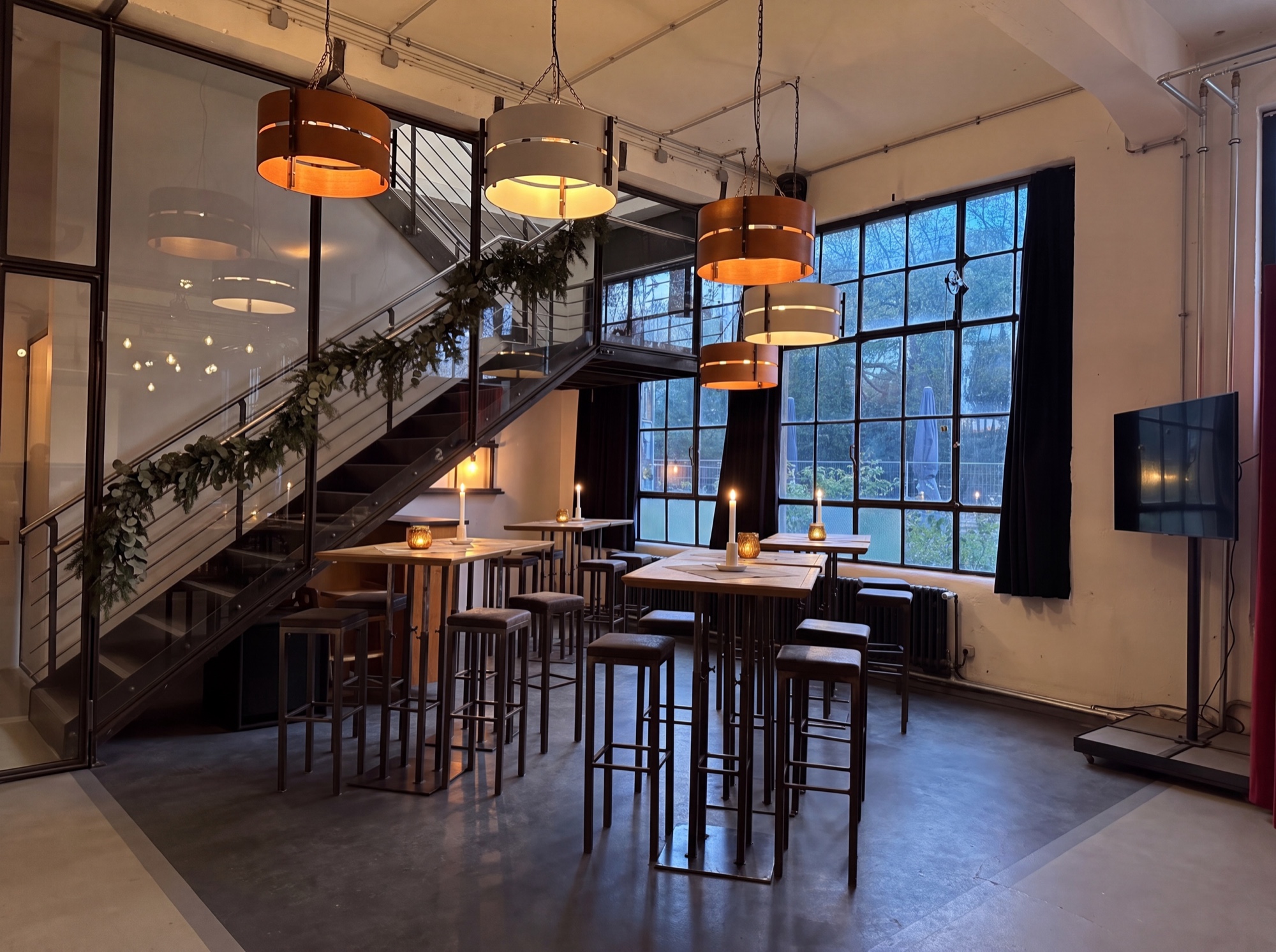 Lounge mit Hochtischen und Weihnachtsgirlande unter der Treppe im Bahnhof Blo