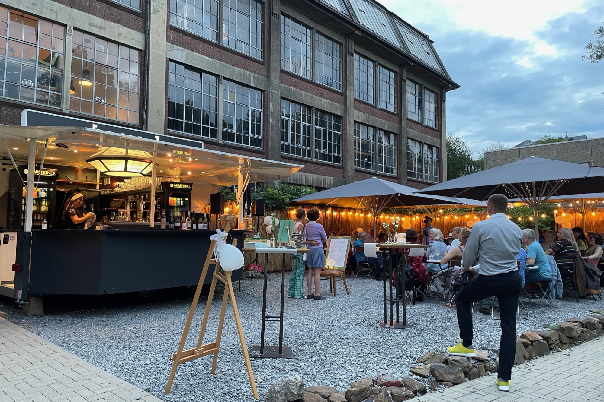 Terrasse des Bahnhof Blo an der Nordbahntrasse in Wuppertal – Außenbar und Gäste in der Abendsonne