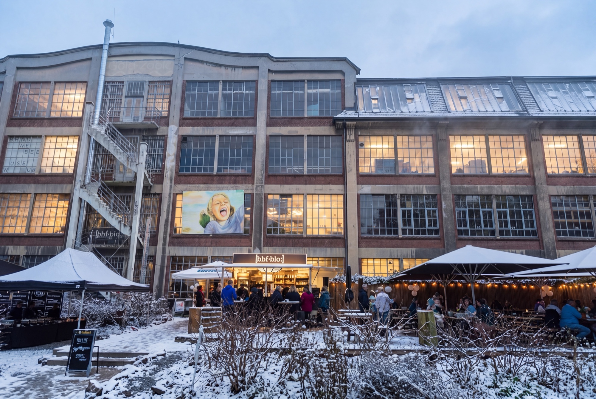 Bahnhof Blo Wuppertal – festlich beleuchteter Firmenweihnachtsmarkt vor dem Gebäude im Schnee