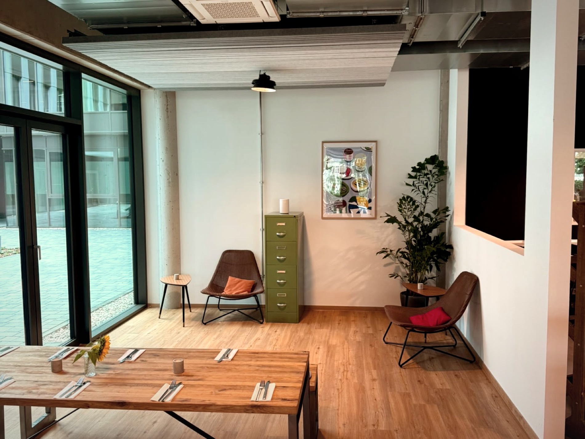 Sitzecke mit Loungesesseln vor der Fensterfront im Gastraum von THE COURT