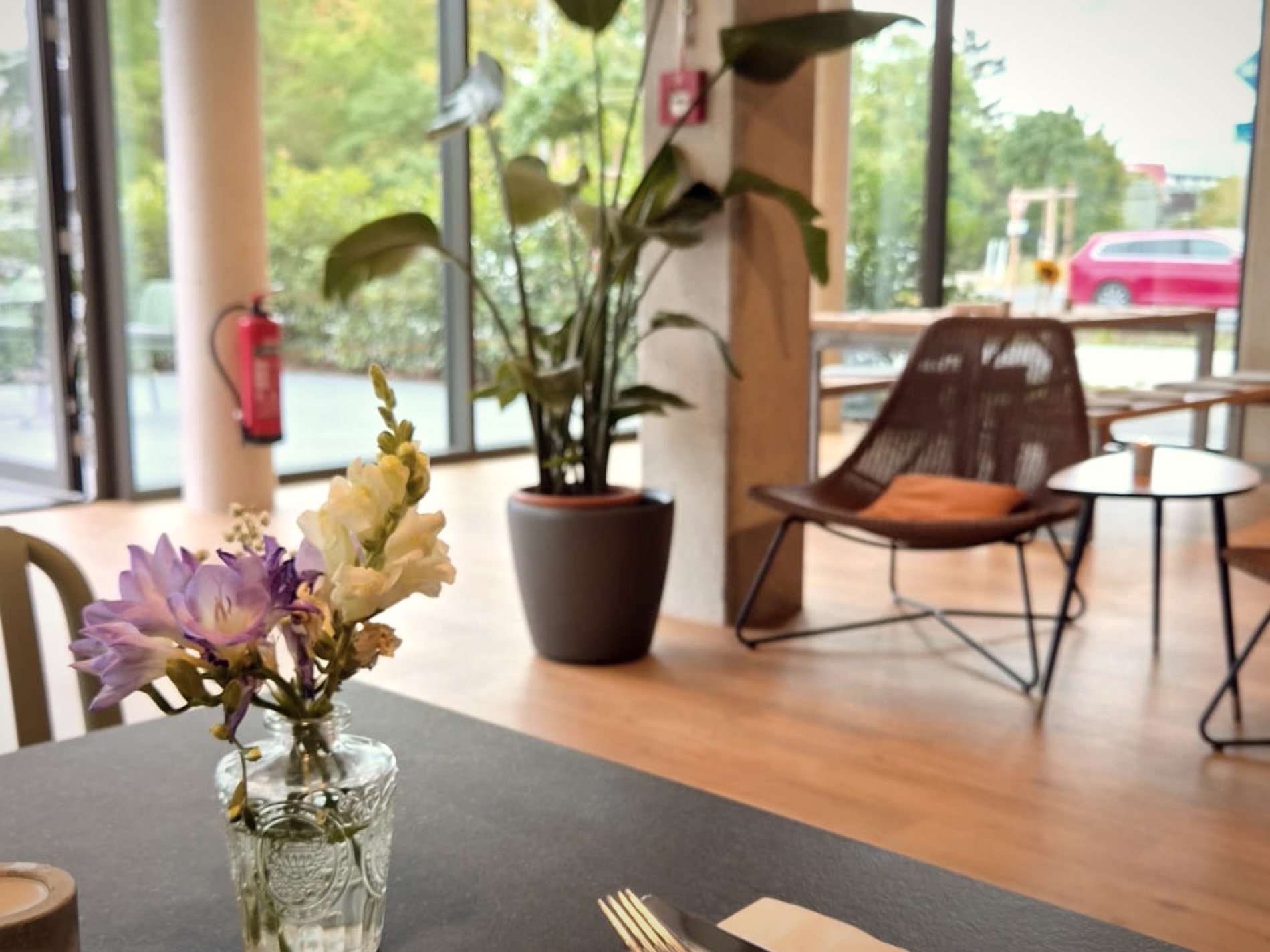 Lounge-Ecke mit Sesseln und Blumen im Gastraum von THE COURT