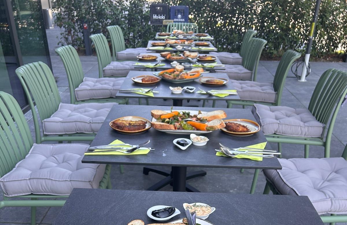 Lange Tafel mit Fingerfood auf der Sonnenterrasse von THE COURT, Blick zum Grün