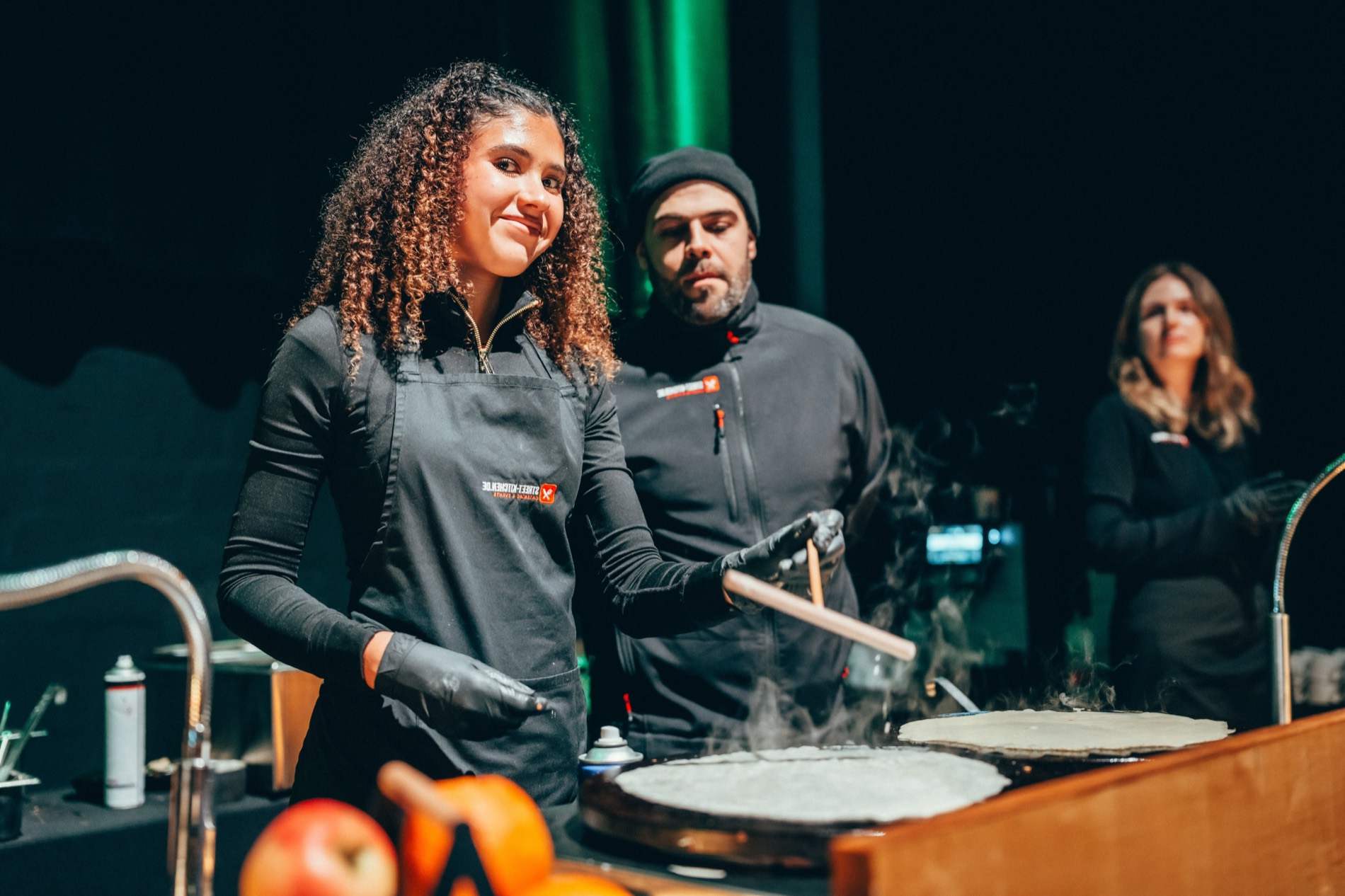 STREET-KITCHEN-Crew an der Crêpe-Live-Station, lächelnde Mitarbeiterin im Vordergrund