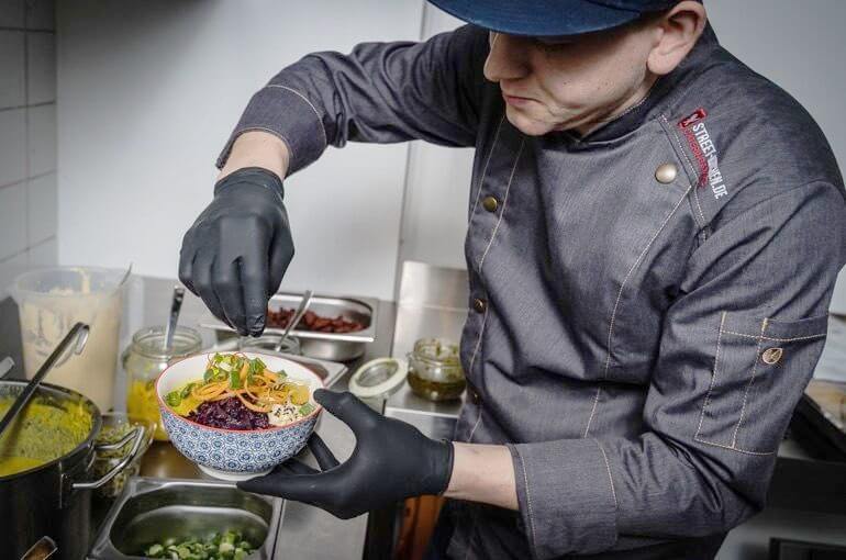 Zubereitung in der K&uuml;che &ndash; Toppings werden auf Bowls verteilt