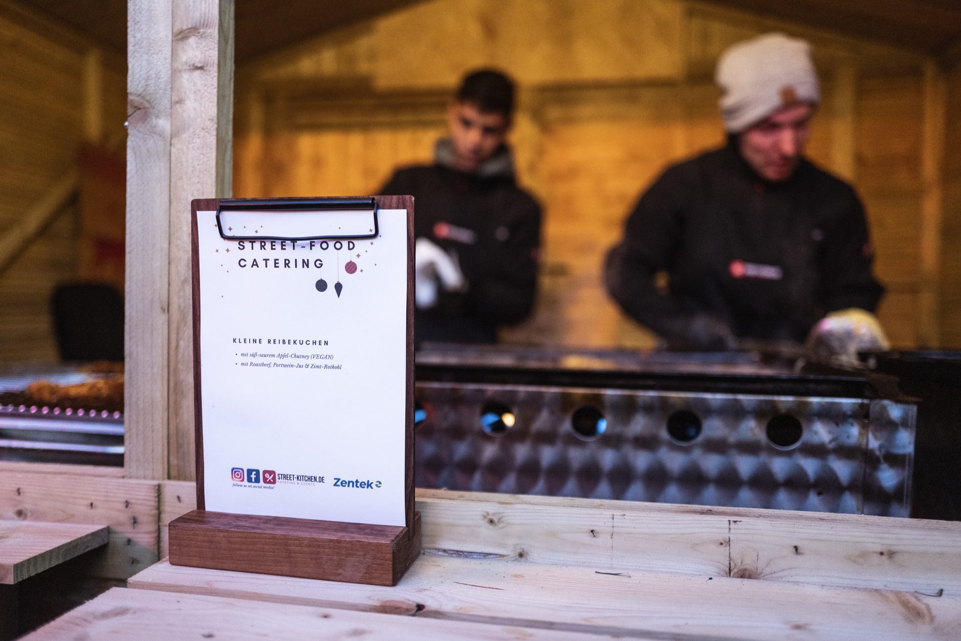 Theke mit Street-Food-Catering-Speisekarte auf dem Firmenweihnachtsmarkt